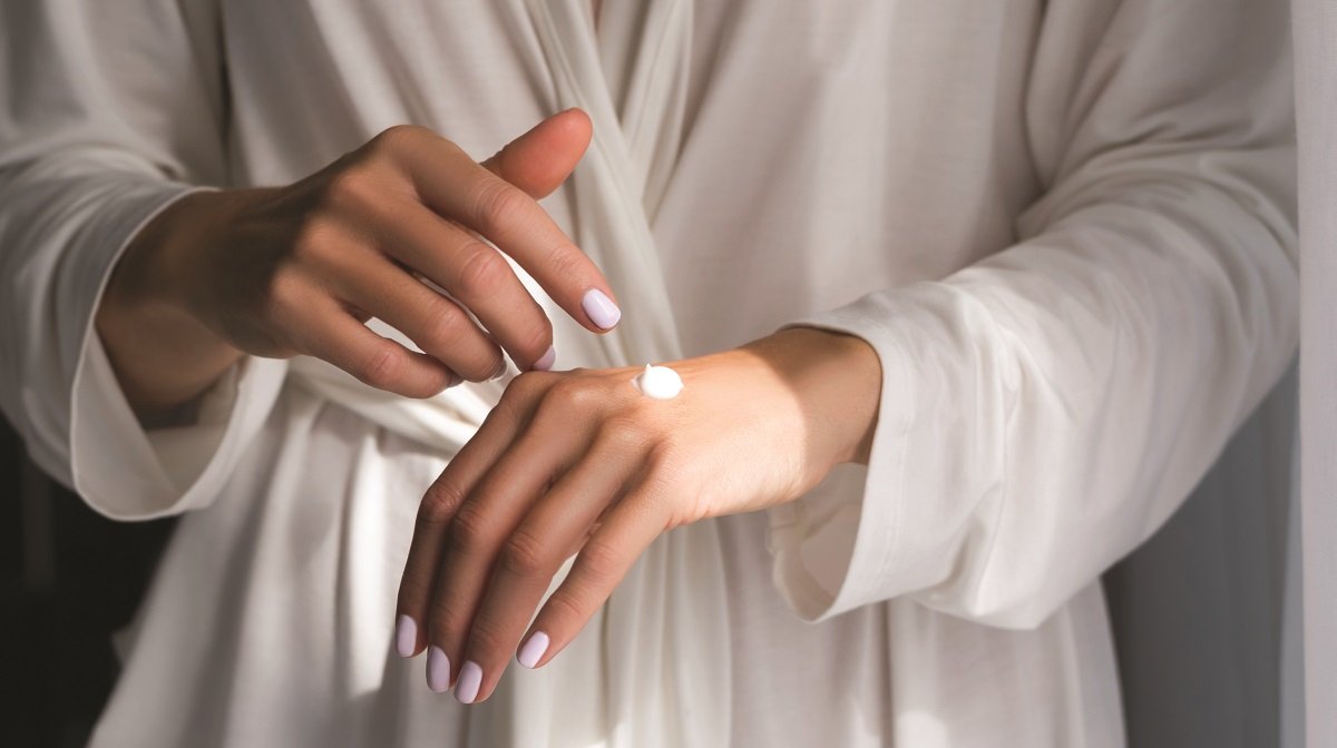 Woman applying Omorovicza's Nourishing Hand Cream on her hands.