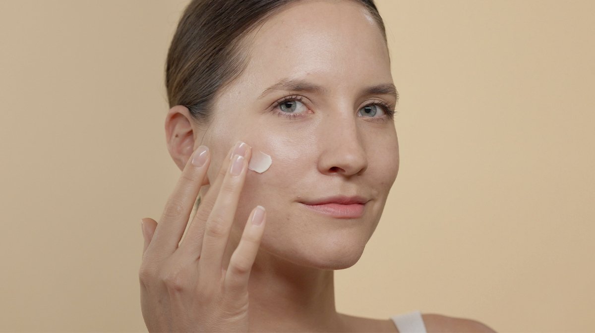 Women applying moisturizer on her face to protect her skin barrier