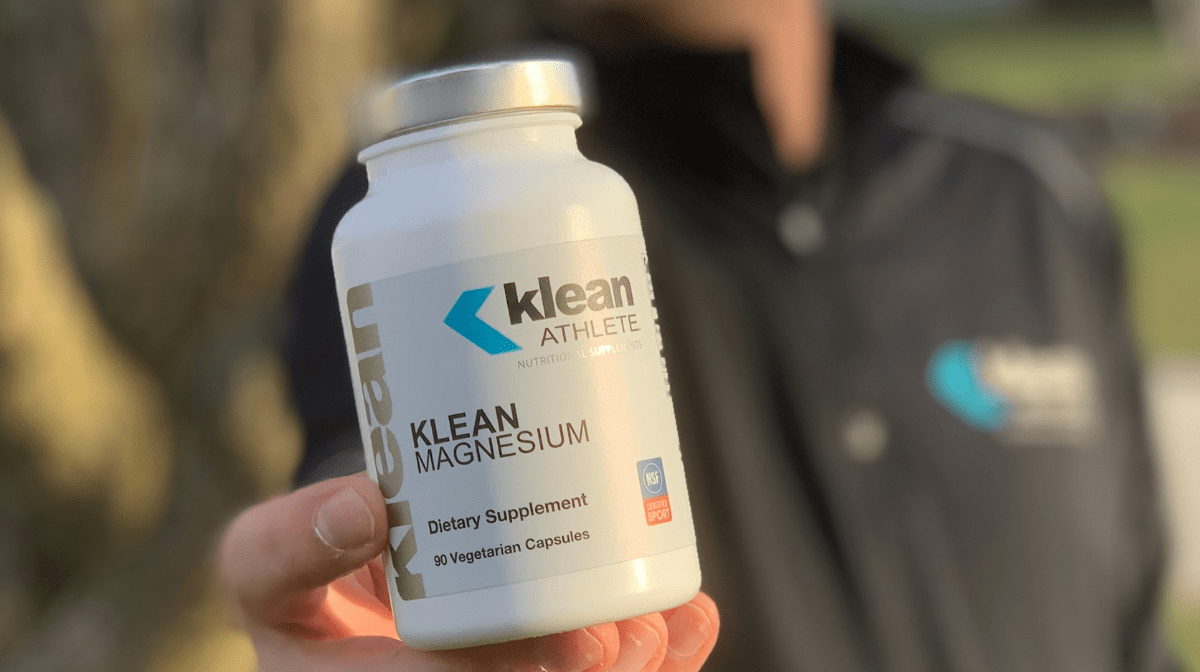 athlete holding bottle of klean magnesium supplements