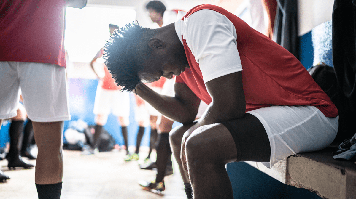 A young male athlete is reviewing his performance after a game