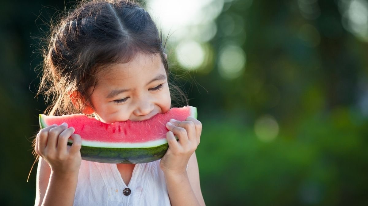 little girl eating a slice of watermelon