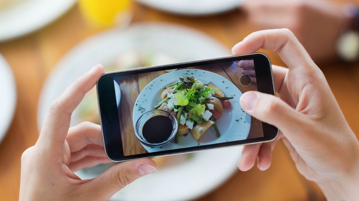 person taking a photo of a meal using their phone