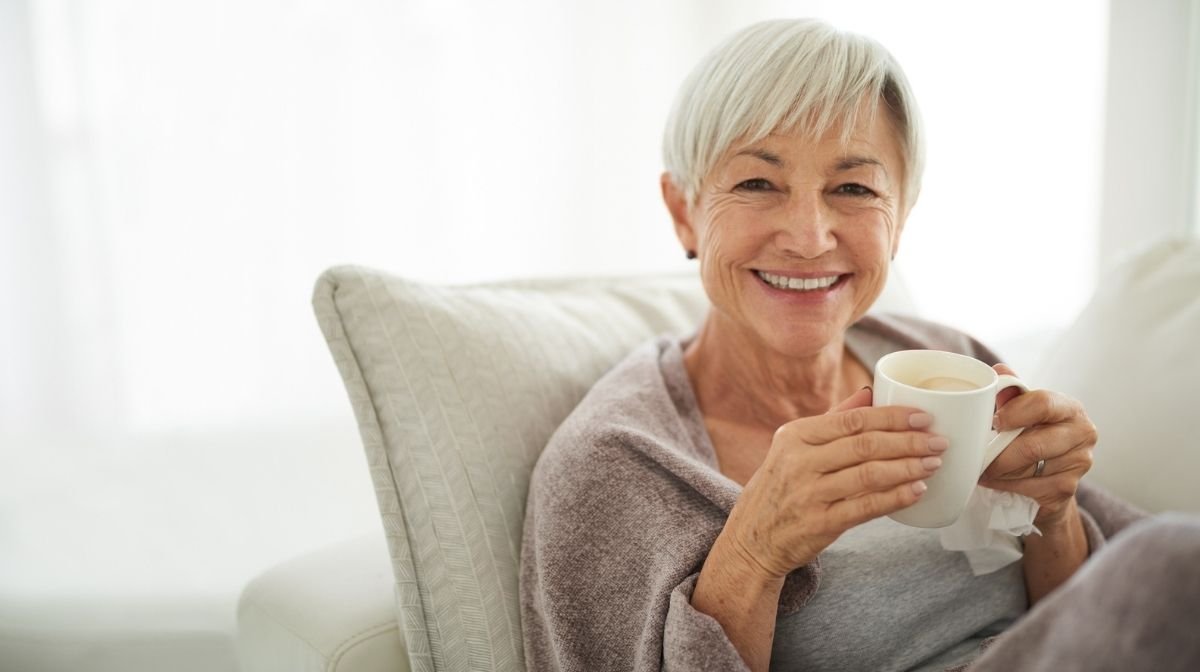 older woman drinking a hot drink