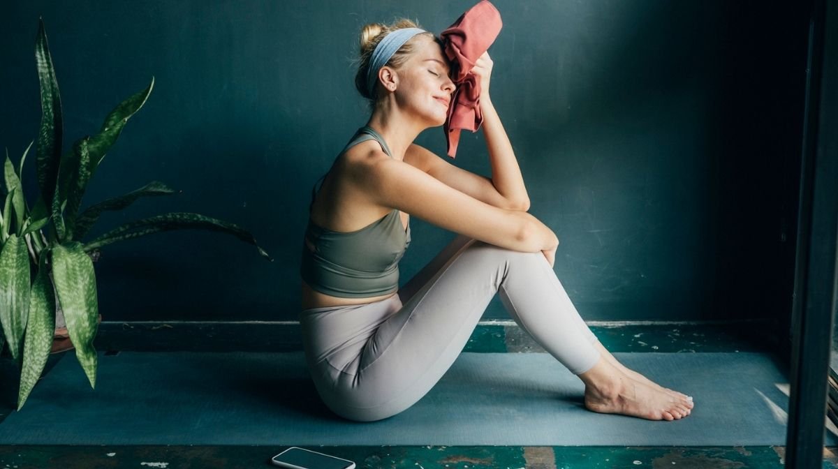 woman mopping her brow after a yoga session