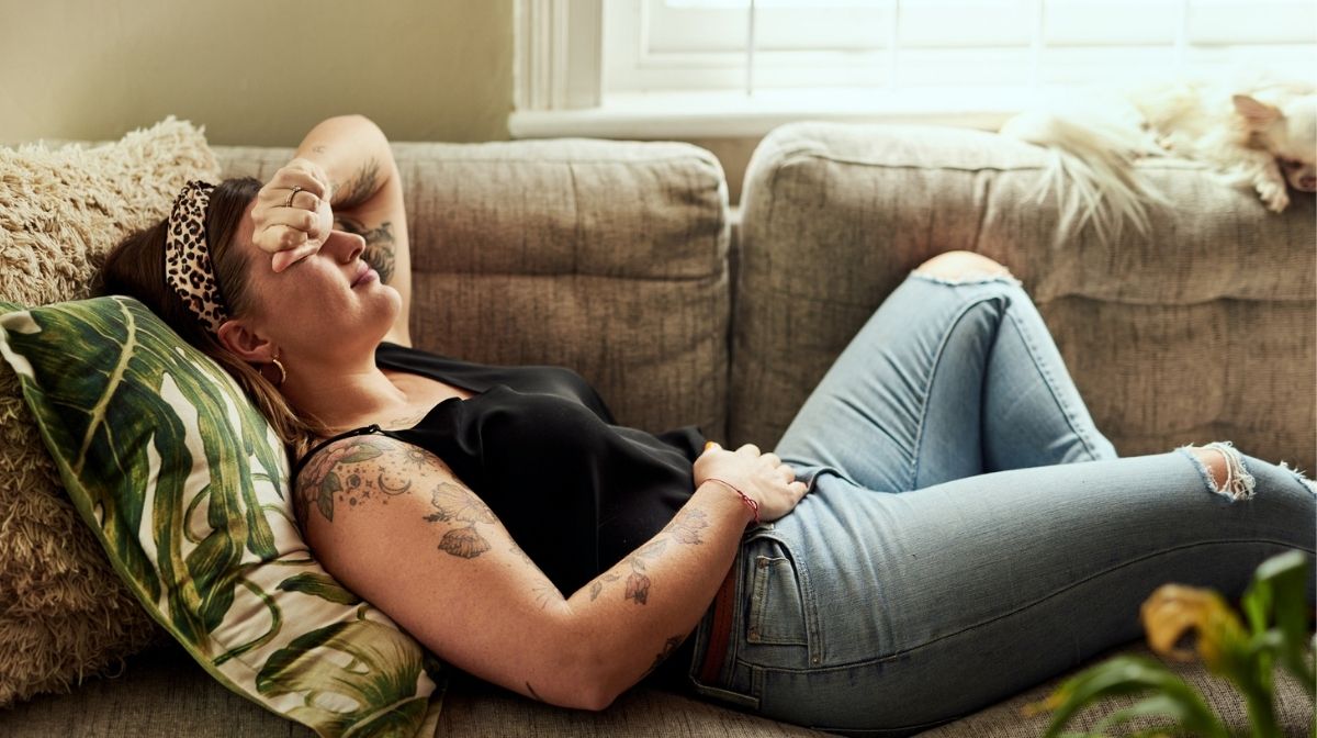 woman lying on the sofa nursing a stomach ache
