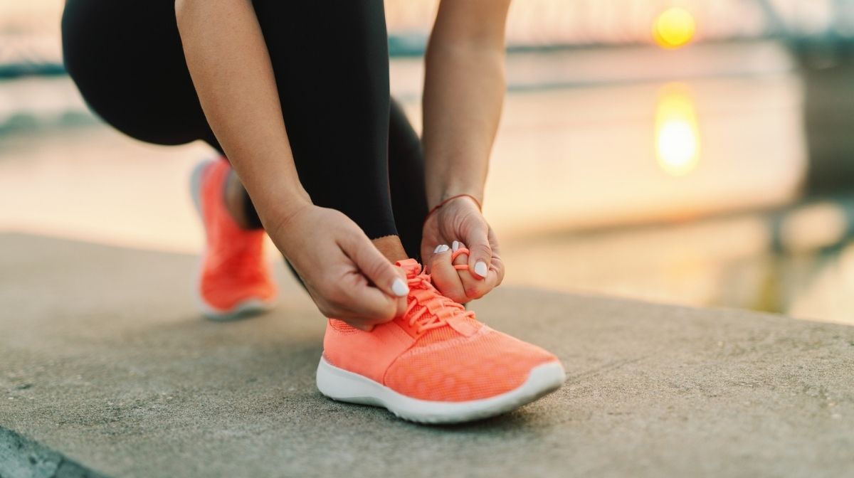 woman lacing up trainers before a run