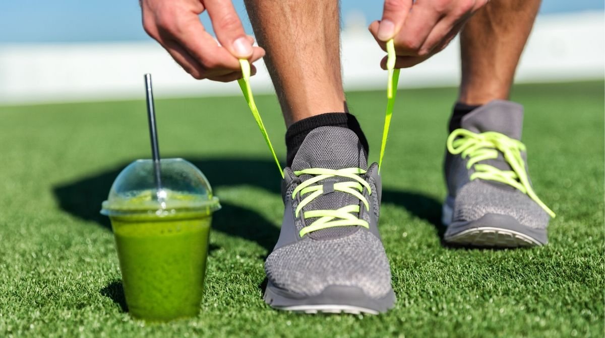 green protein smoothie in a cup on some grass