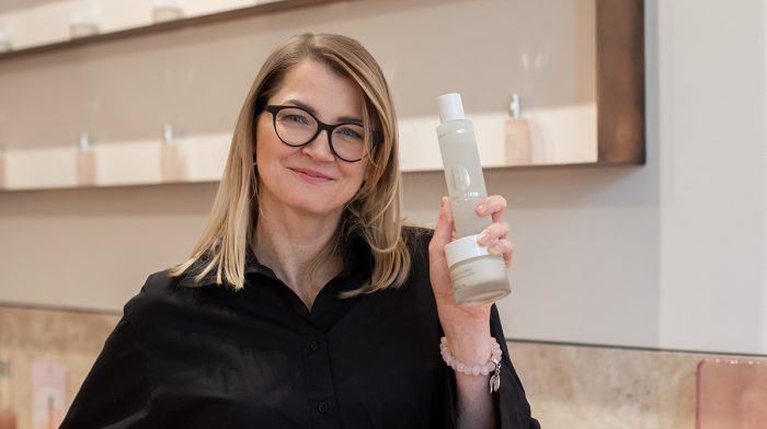 Woman smiling and holding Omorovicza's products