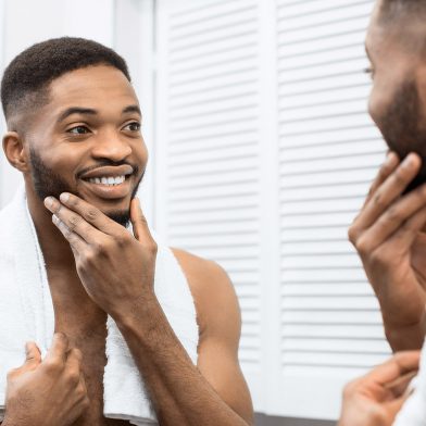 Man smiling in the mirror with clear skin