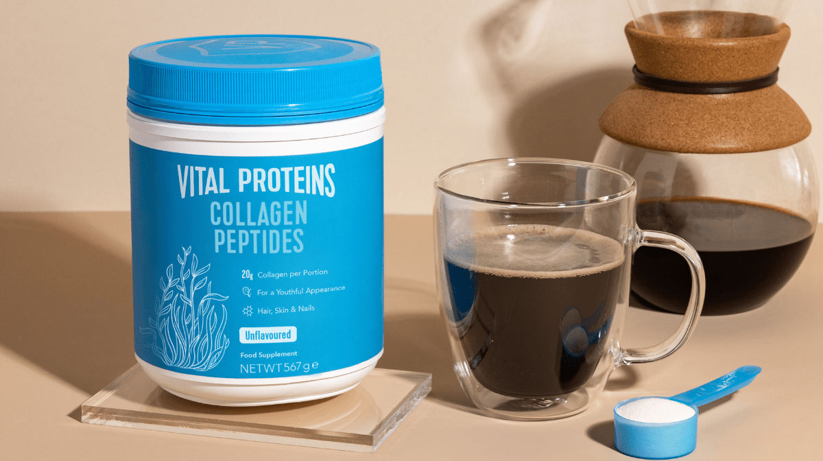 Vital Proteins Collagen Peptides standing on the table next to a cup of coffee