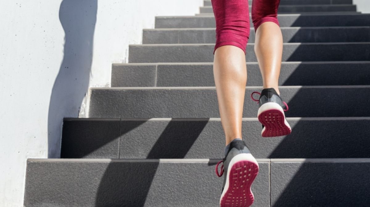 woman in workout gear walking up stairs