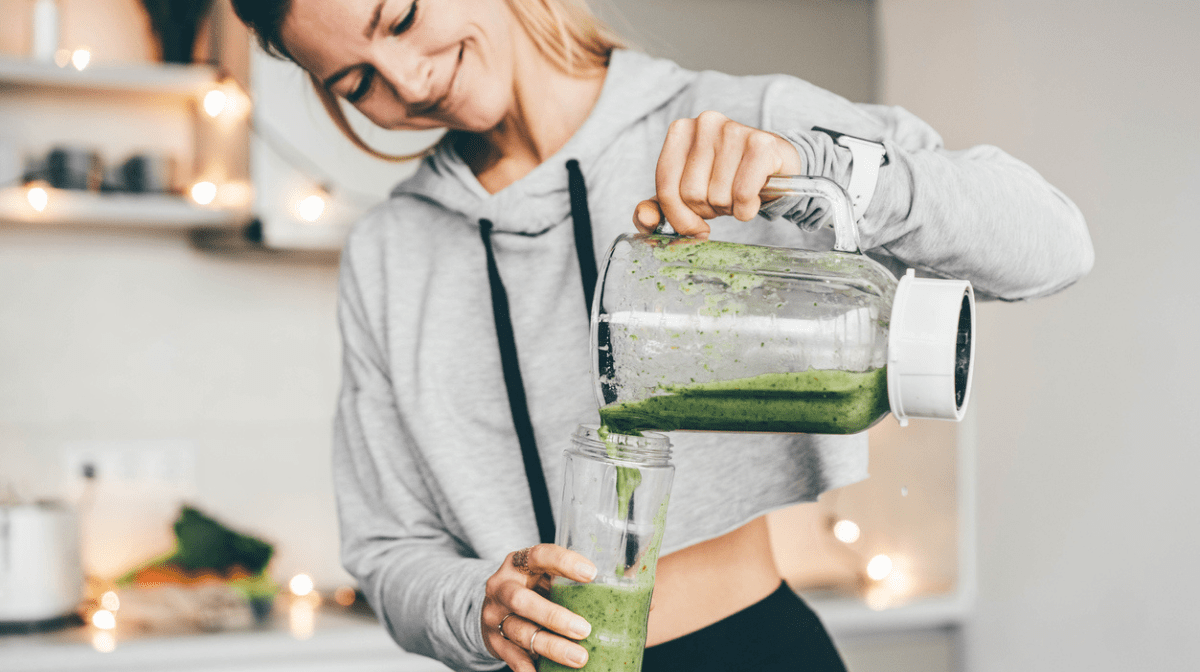 Woman pouring smoothie to glass.