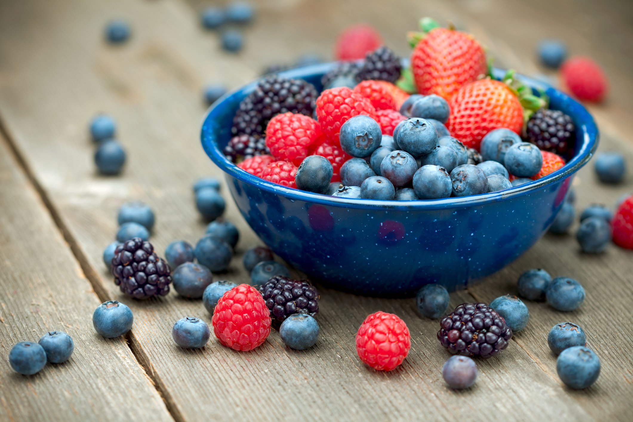 berries and cherries in a blue bowl
