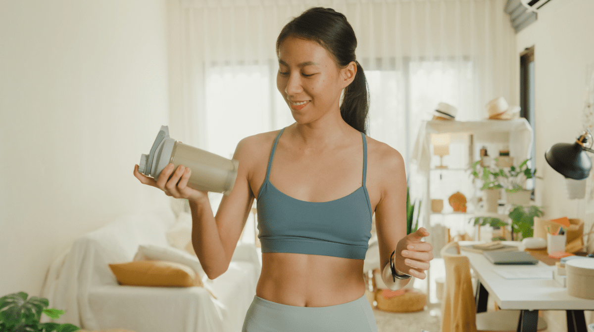 Young woman preparing a collagen shake at home.