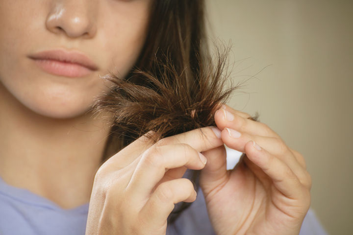 woman looking at ends of hair