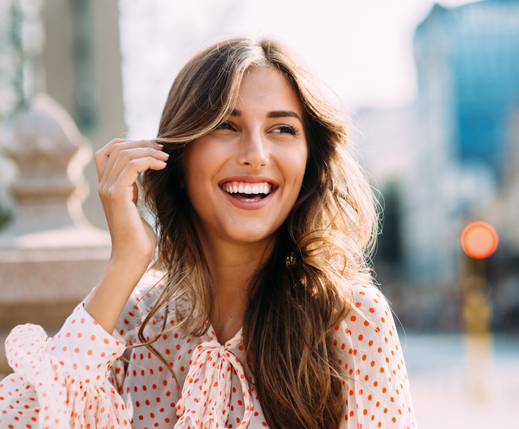 woman laughing while touching hair