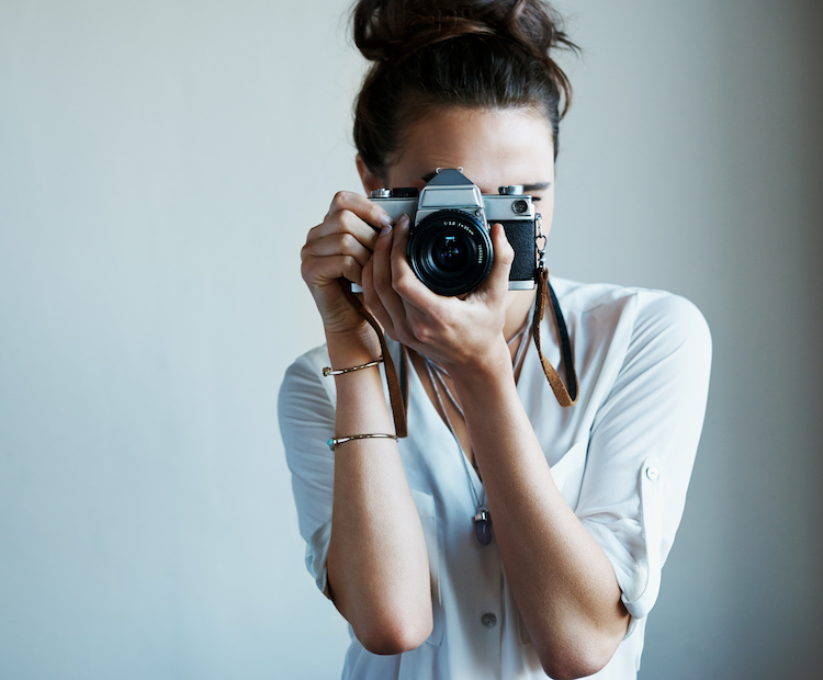 woman holding a camera and looking through it