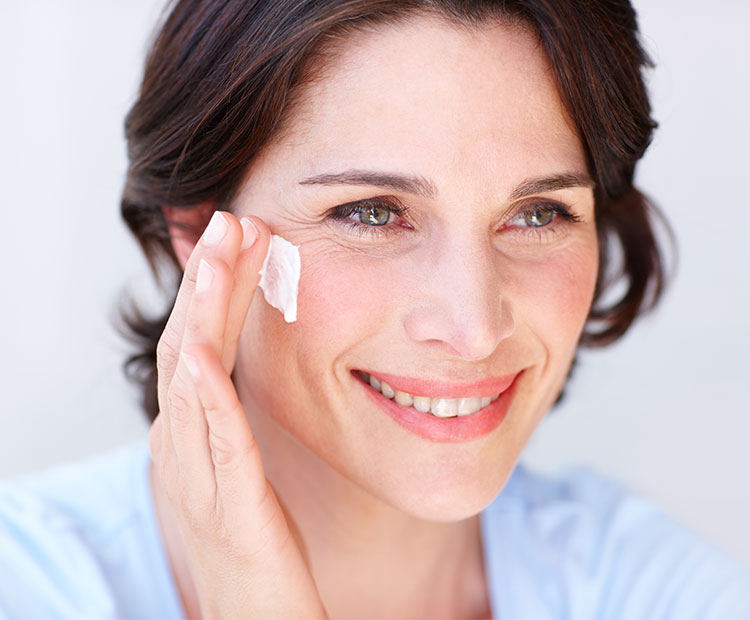 Middle aged woman applying face cream 2 | Dermstore Blog