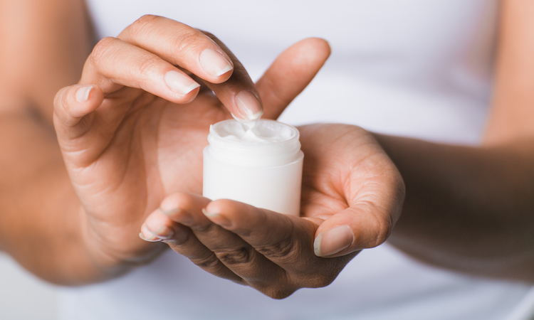 woman holding jar of moisturizer