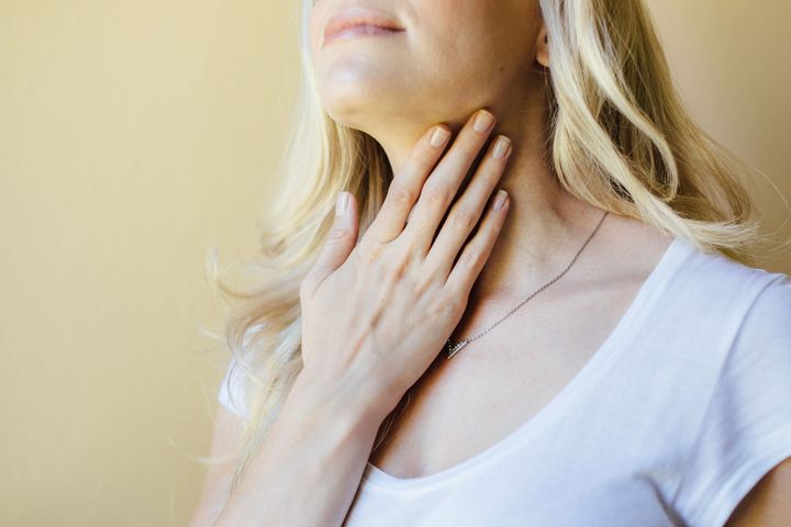 woman touching her neck