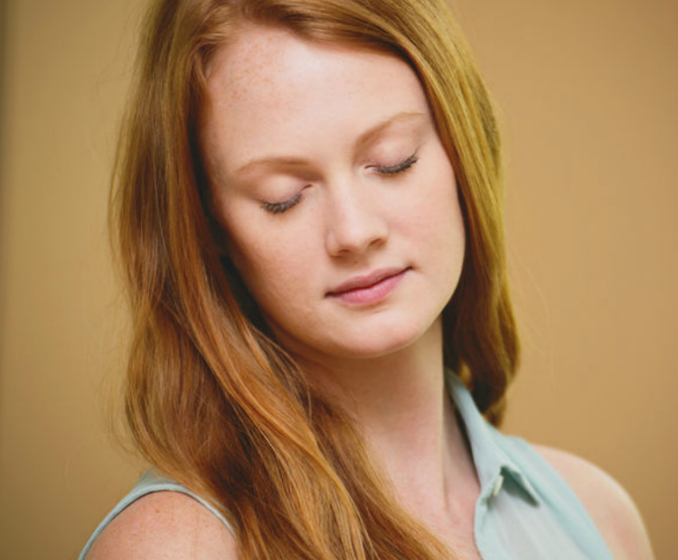 red haired woman with thinning eyebrows with her eyes closed