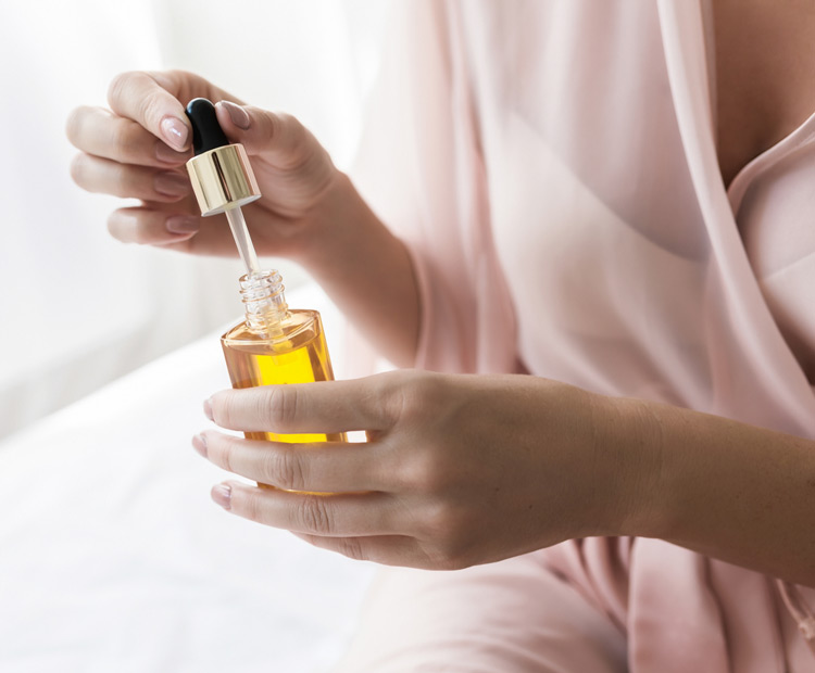 woman holding bottle of essential oil
