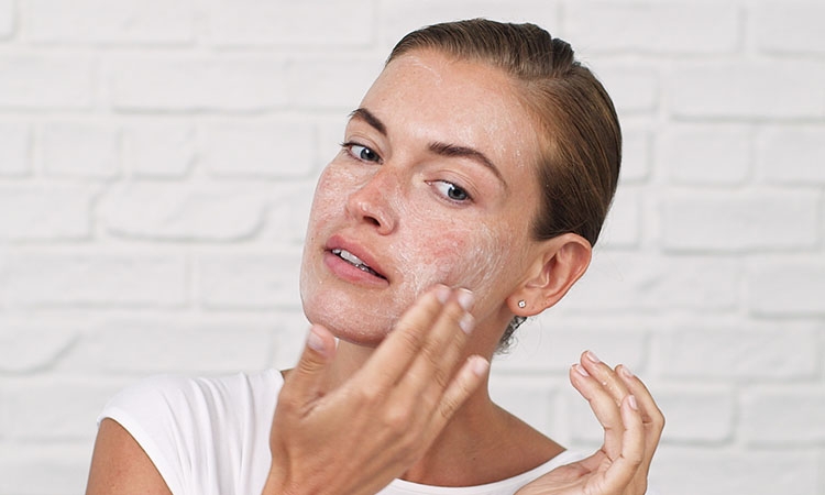 woman exfoliating her face 2