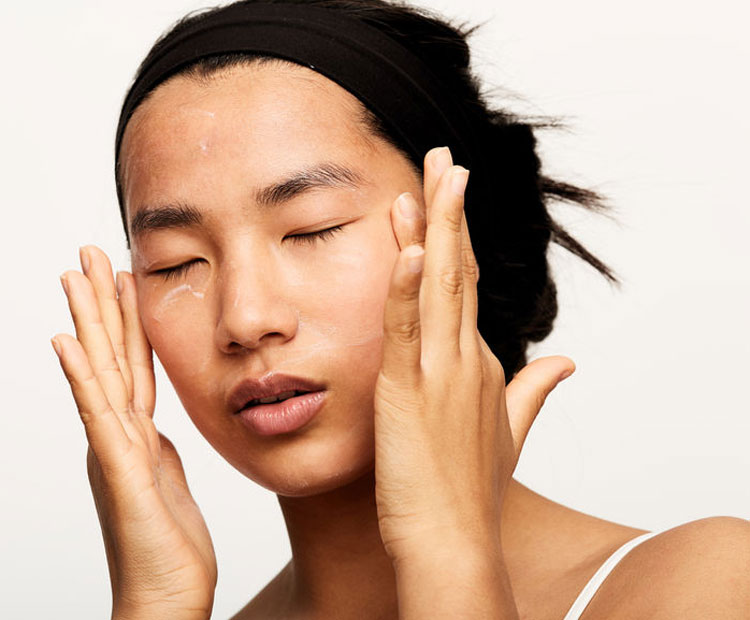 Woman applying skin care products