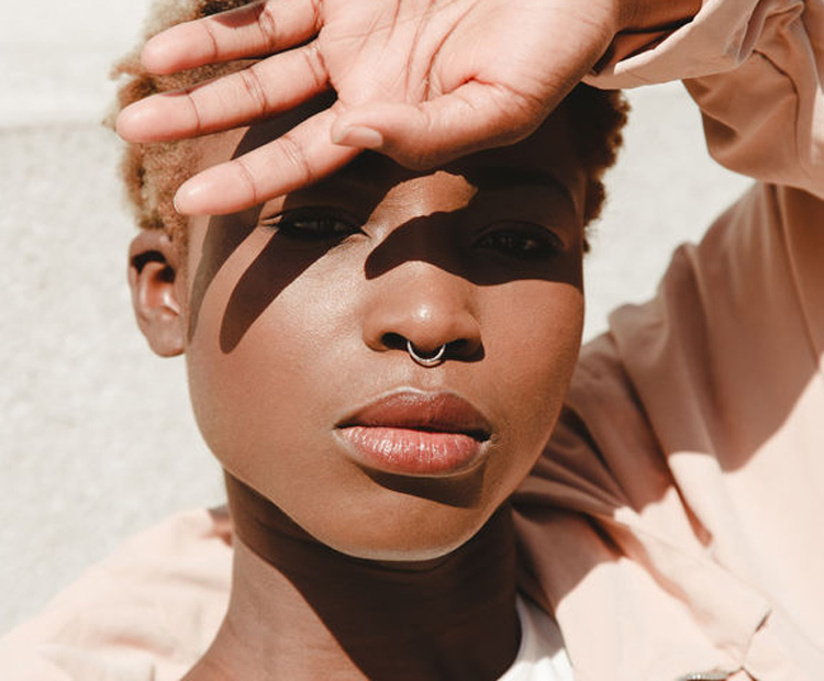 Woman shielding face from sun - hyperpigmentation