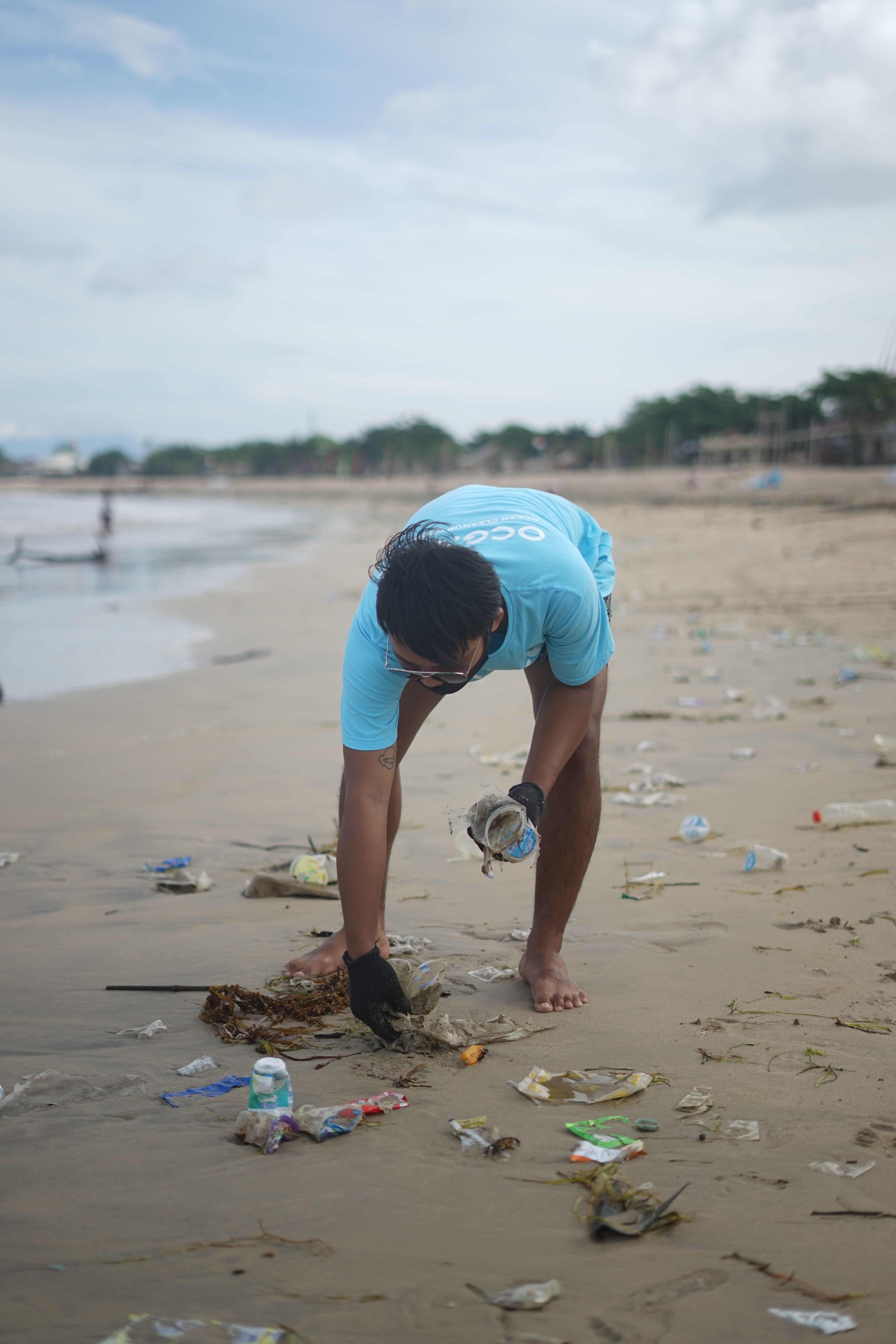 Man picking up rubbish from the beach