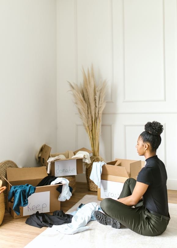 Women clearing out her space into boxes to sell or donate