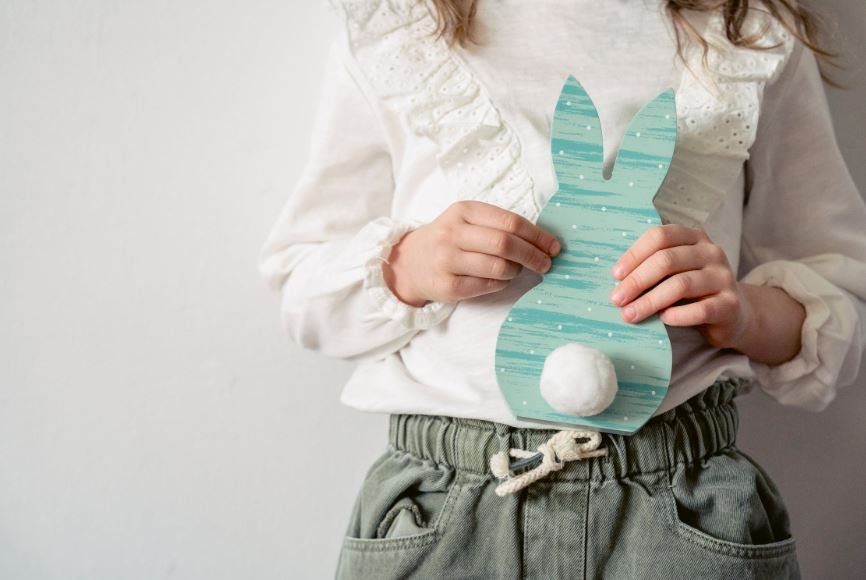 Young girl holding cardboard Easter craft of a bunny