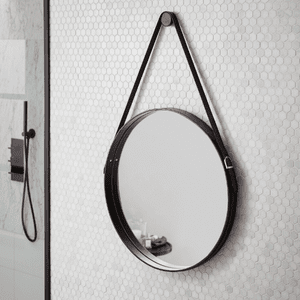 an image of a round black mirror hanging on a bathroom wall