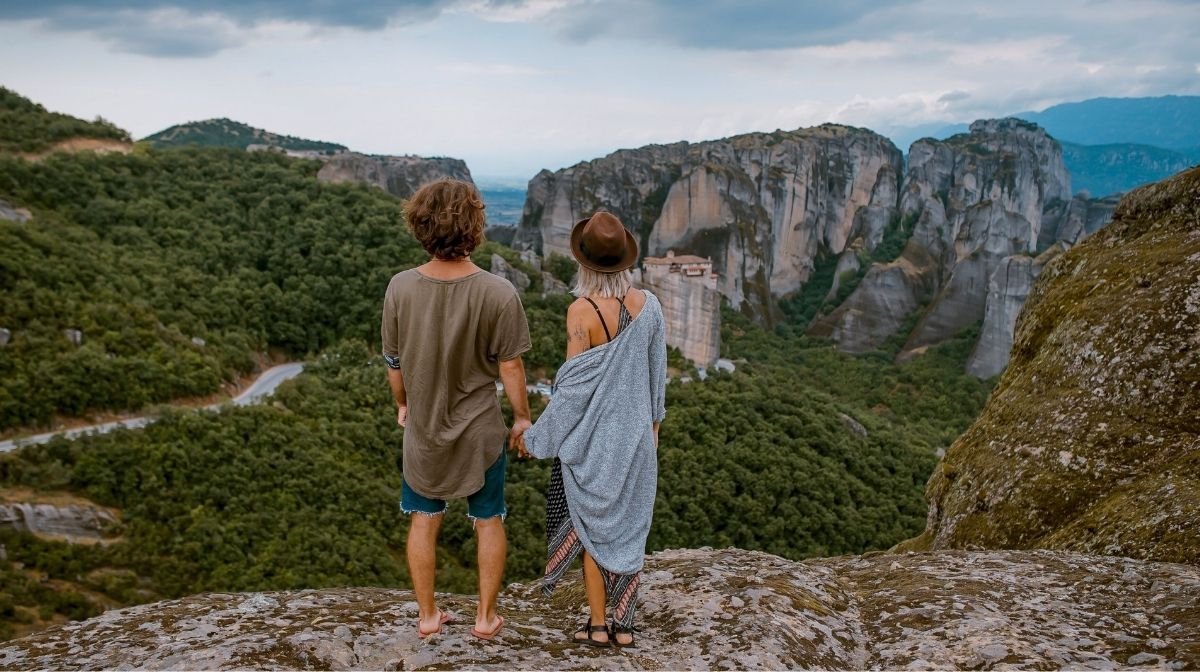 Нужны ли мужчинам и женщинам разные витамины? Пара стоит на скале и любуется видом гор.
