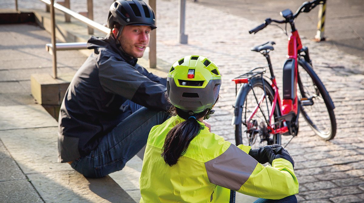 Two cyclists wearing the Urban Luminite Helmet and the Pisspot Reflective Helmet