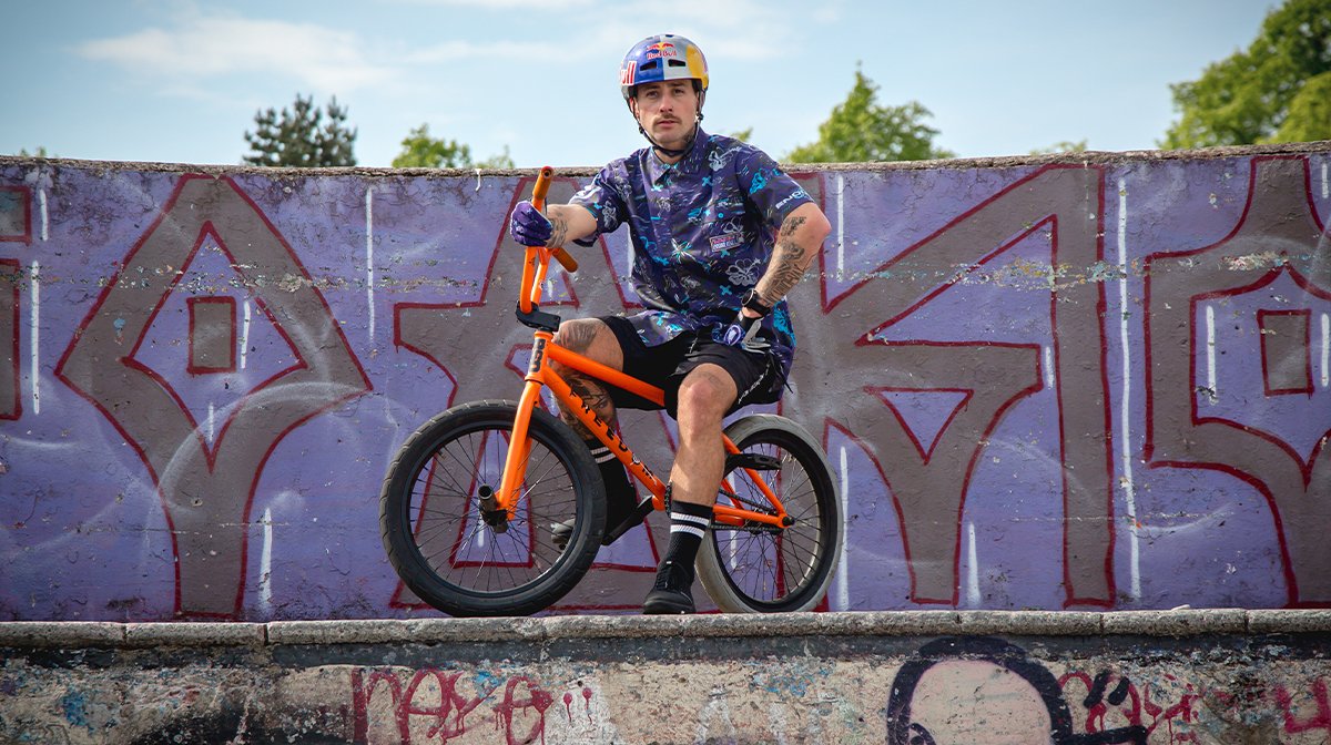 BMX rider poses at top of ramp