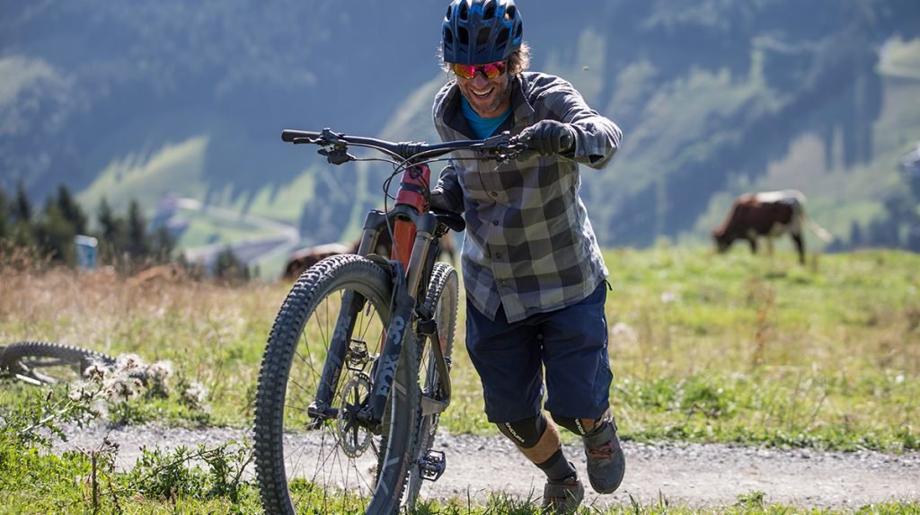 cyclist pushing bike up hill