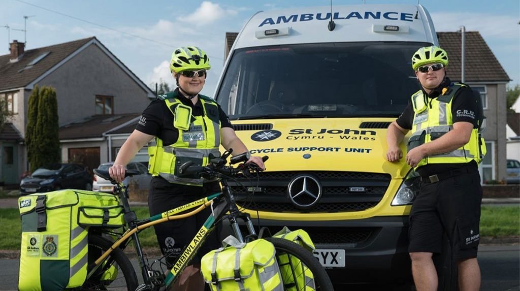 Emergency response cyclist poses infront of ambulance