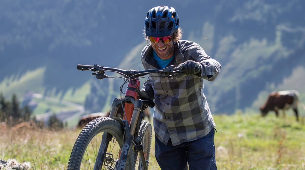 Man pushes bike uphill