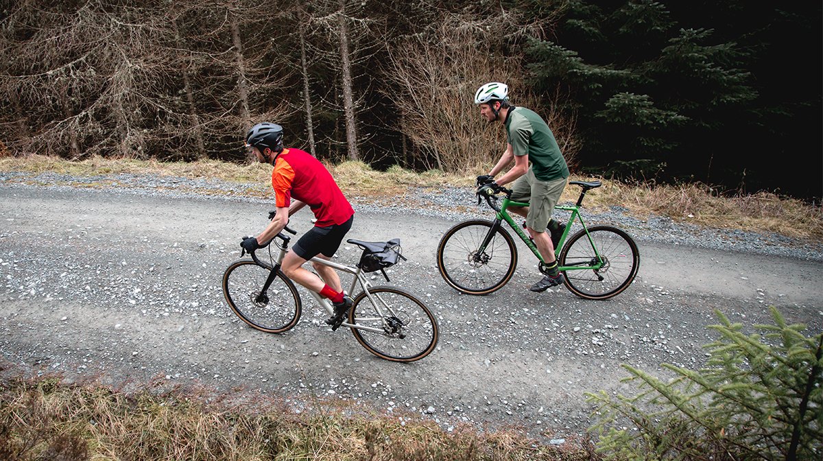 Two mountain bikers travel along a road
