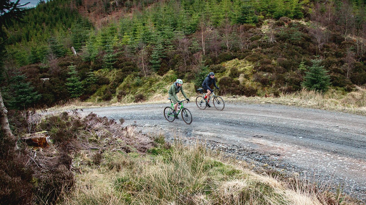 Two Endura cyclists head down gravel road dressed in Endura gear