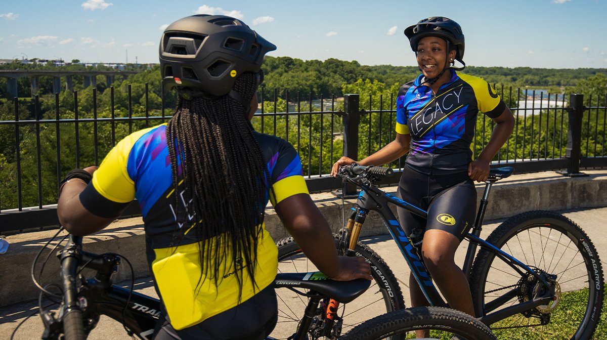 Two women chat while wearing brightly coloured Endura cycling gear