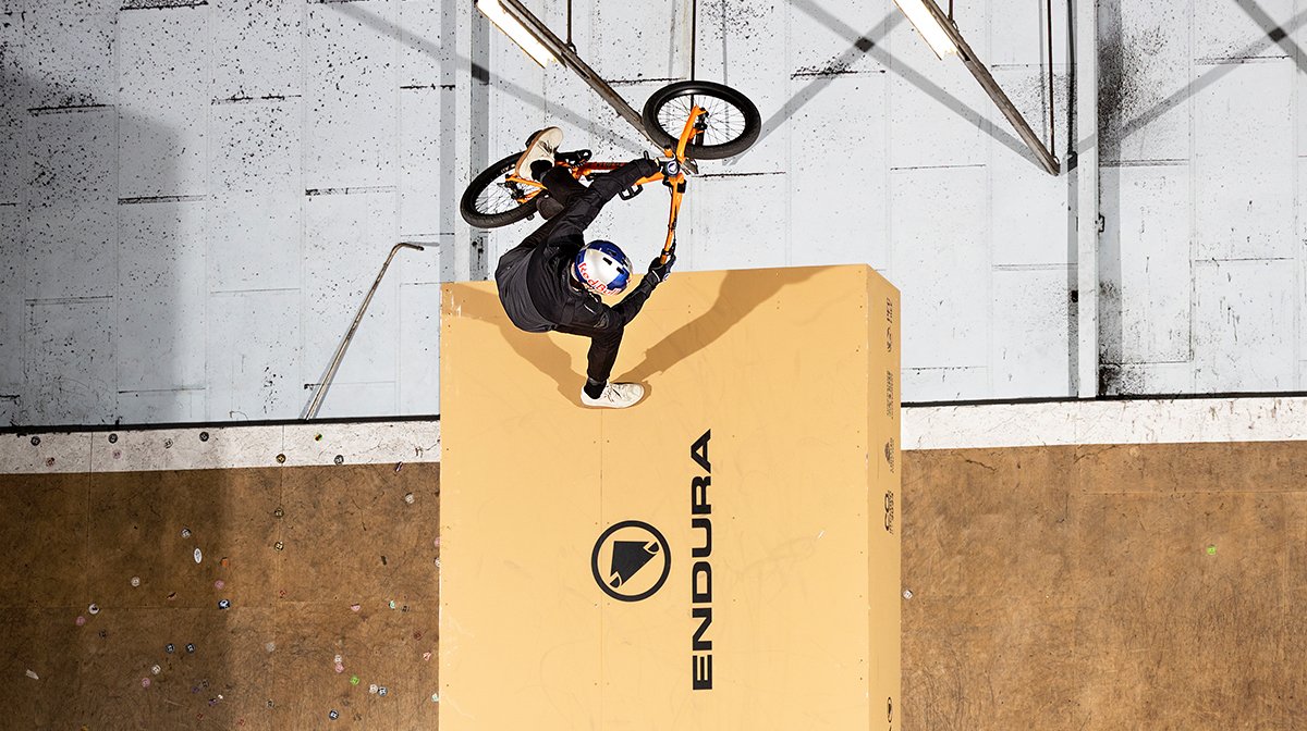 Endura BMXer performs trick atop a giant Endura shoebox