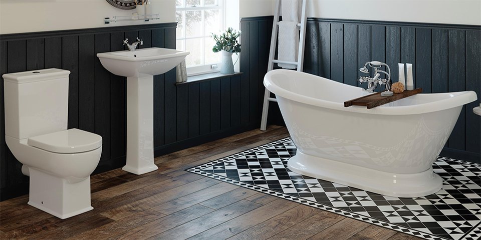 A picture of a stylish bathroom with dark wood flooring, and a white sink, toilet and bath.