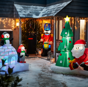 an image of a variety of outdoor christmas lights including inflatable lights and gold icicle lights outside the front of a house