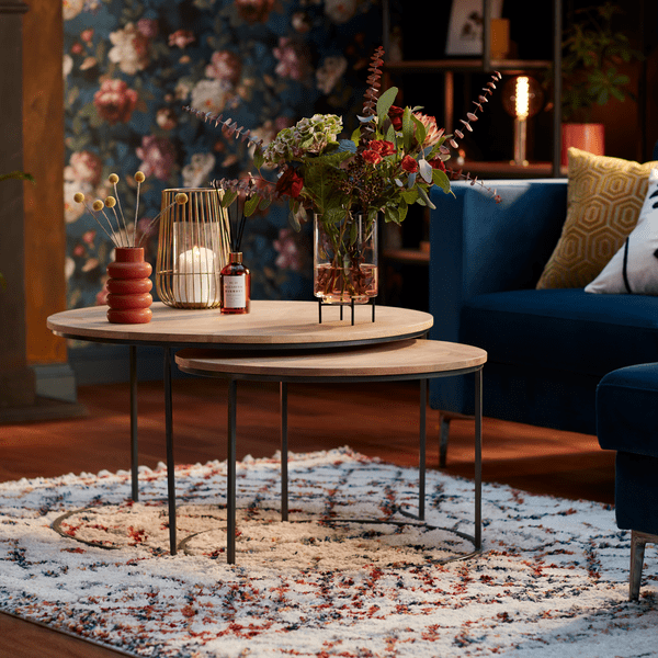 an image of a wooden coffee table on a patterned rug in a wallpapered living room