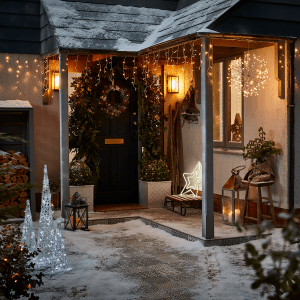 an image of a front of a house decorated with Christmas lights and a Christmas wreath on the front door 