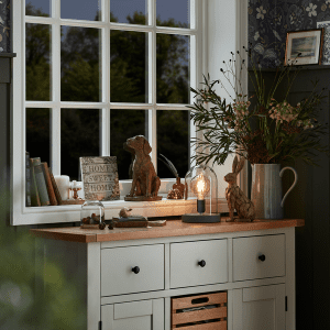 an image of a wooden dresser in front of a window 