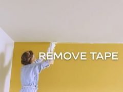 Woman removing masking tape from ceiling
