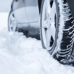 image of a car tire stuck in the snow 